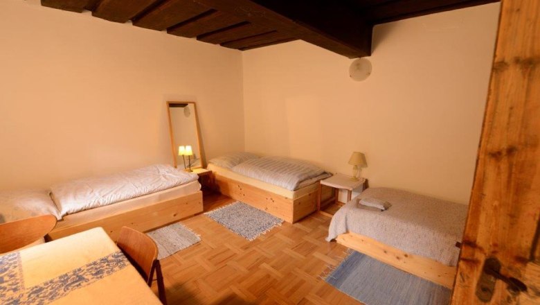 Dreibettzimmer - Mariahaus, © Martina Heilingsetzer Dreibettzimmer mit Holzmöbeln und Parkettboden.