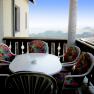 Balcony, © Anke Spreitzer Balcony with table and colorful chairs, view of the countryside.