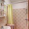 Bathroom, © Wachahof Small bathroom with yellow shower curtain, washbasin and patterned tiles.
