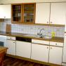 Kitchen, © Anke Spreitzer Kitchenette with white cupboards, stove, sink and dishwasher.