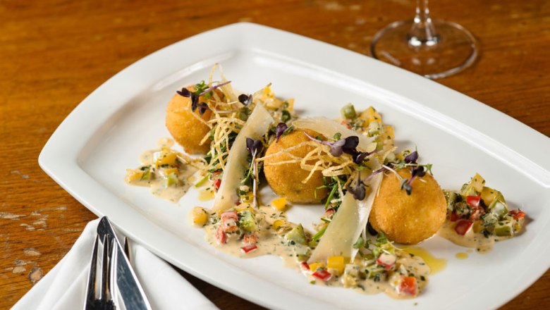 Hotel Post-Hönigwirt, © Niederösterreich Werbung/Rita Newman Drei goldbraune Kroketten auf einem weißen Teller, garniert mit Gemüse und Sauce.