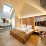 Gästehaus Flora - Giebelzimmer, © Herbert Lehmann Modernes Hotelzimmer mit Dachfenster, Doppelbett und stilvoller Einrichtung.