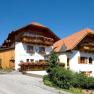 Landgasthof Fally, © Ulrike Korntheuer Ein traditioneller Landgasthof mit Holzfassade und Blumenkästen unter blauem Himmel.