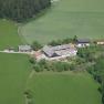 The Wachahof from above, © Wachahof Aerial view of a farm surrounded by green fields and forests.
