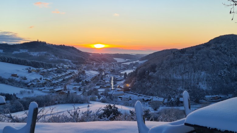 20211210_074118, © Gemeinde Schwarzenbach Winterlandschaft mit Sonnenaufgang über einem verschneiten Dorf in einem Tal.