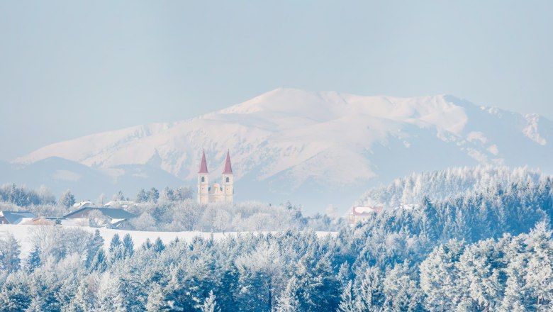 Wallfahrtskirche Maria Schnee, © Wiener Alpen, Foto: Franz Zwickl Winterlandschaft mit Kirche und Bergen im Hintergrund.