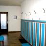 Hallway, © Anke Spreitzer Hallway with wooden floor, colorful wall design and coat hooks.