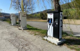 E-Ladestation - Parkplatz Gasthof Pichler, © Wiener Alpen Drei E-Ladestationen auf einem Parkplatz bei einem Gasthof, umgeben von Bäumen und Landschaft.