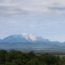 Ausblick, © Familie Görg Ausblick auf eine Landschaft mit bewaldeten Hügeln und einem schneebedeckten Berg im Hintergrund.