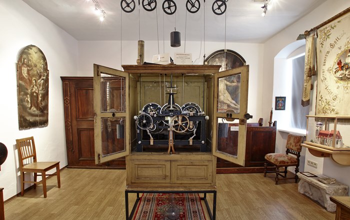 Kirchschlag town museum, © Wiener Alpen, Foto: Bene Croy Interior view of a museum room with antique clock and historical furniture.
