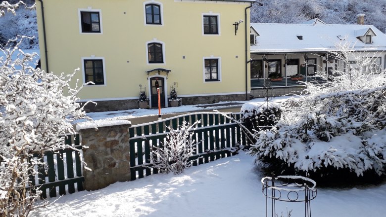 Outbuilding Pension Hendling, © Josef Hendling Snow-covered yellow building with green fence in the foreground.