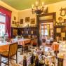 Stüberl, © Christian Krems Gemütliches Restaurant mit Holzmöbeln, roten Vorhängen und dekorativen Bildern an den Wänden.