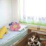 Bedroom 3, © Anke Spreitzer Children's room with bed, cuddly toys and toy horse.