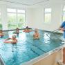 Unique carbonic acid movement pool in Austria, © Gesundheitsresort Königsberg People in an exercise pool with swimming noodles, supervised by a trainer.