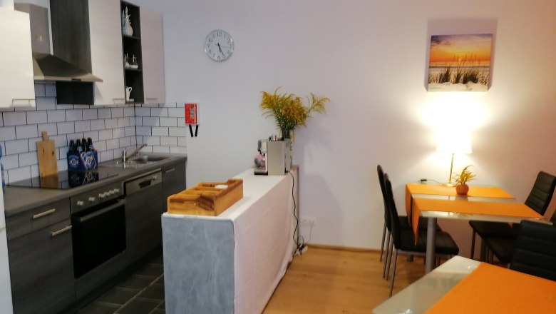 Kitchen in the breakfast room, © Pension zum Spitz Modern kitchen with dining table and orange placemats.