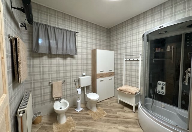 Zimmer Deluxe, © Schloss Gut Ziegersberg Modernes Badezimmer mit Duschkabine, Bidet, Toilette und Schrank auf Holzfußboden.