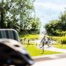 Garden, © Wiener Alpen / Martin Fülöp A bicycle is parked next to a pond with a fountain in a sunny garden.