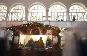 Christkindlmarkt im Schloss Katzelsdorf, © Wiener Alpen/Stefanie Reisenbauer Weihnachtlich dekorierter Punschstand mit Lichtern und Menschen davor, im Hintergrund das Schloss Katzelsdorf