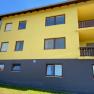 Anke's vacation apartment, © Wiener Alpen Yellow building with brown windows and balconies, blue sky in the background.