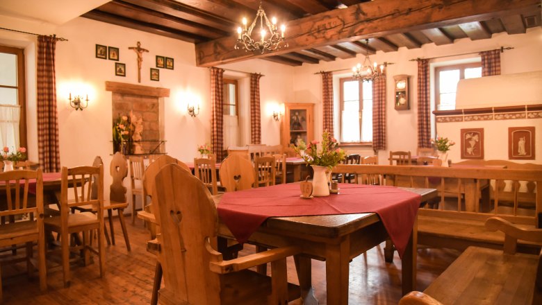 Parlor, © Genussbauernhof Böhm Cozy parlor with wooden furniture, red tablecloths and chandeliers.