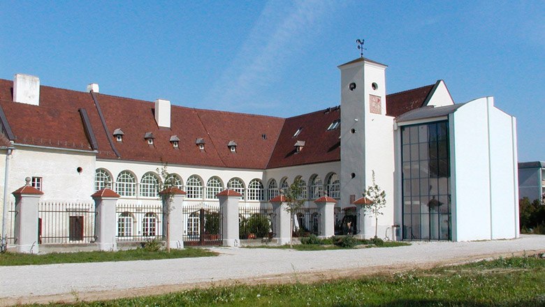 Schloss Katzelsdorf, © Ing.Paul Draxler Schloss Katzelsdorf mit modernem Anbau und historischem Gebäude. Weiße Fassade mit gerundeten Fenstern, rotes Dach und großer Innenhof
