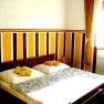 Bedroom 2, © Anke Spreitzer A bedroom with a double bed, striped wall and yellow curtains.