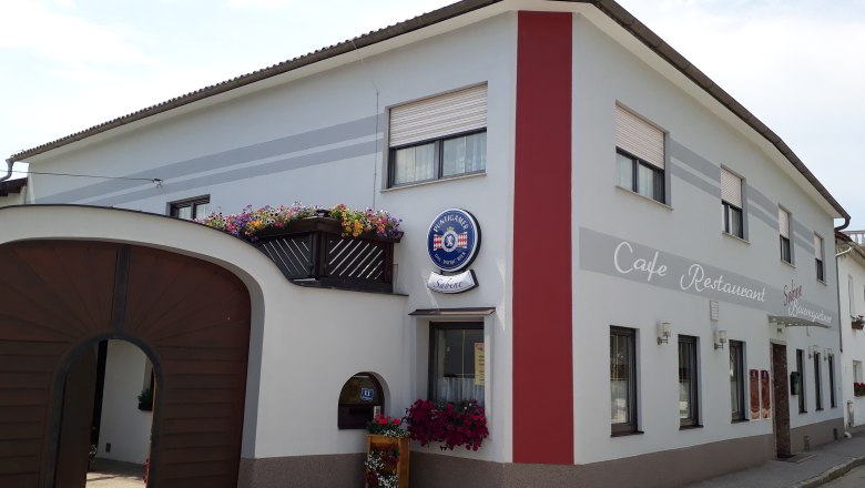 Café Restaurant Sabine, © Sabine Schneeweis Außenansicht Café Sabine mit Holztor, weiß-roter Fassade und Aufschrift "Café-Restaurant".