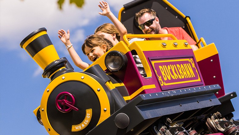Eis-Greissler adventure park Bucklbahn, © Blochberger Eisproduktion GmbH Two children and an adult are sitting in a carriage on the Bucklbahn.