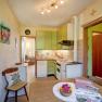 Kitchen, © Wachahof Kitchen with green cupboards, dining table with flowers, door to the living room.