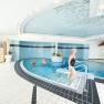 The indoor pool, © Gesundheitsresort Königsberg Indoor pool with people in the water and a woman walking up the stairs.