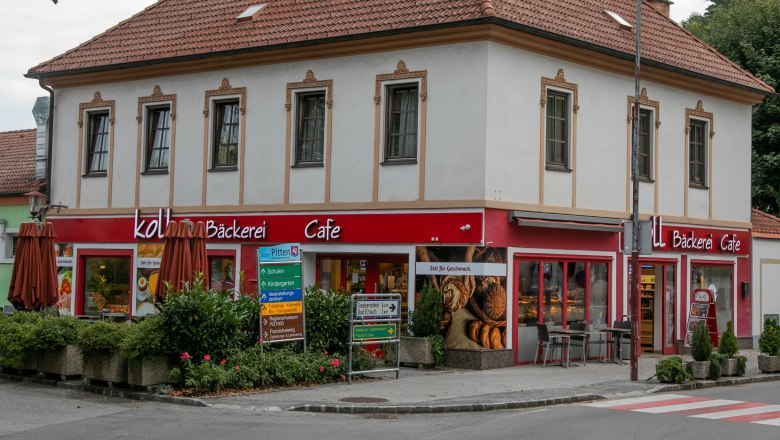 Fachgeschäft mit Café in Pitten, © Koll GmbH Ein zweistöckiges Gebäude mit einem Café und Bäckerei im Erdgeschoss in Pitten.