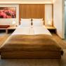 Gästehaus Flora, © Herbert Lehmann Modern eingerichtetes Hotelzimmer mit Doppelbett, Nachttischen, Lampen und einem Bild an der Wand.