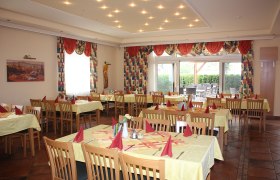 Ein elegantes Restaurant mit gedeckten Tischen und roten Servietten.