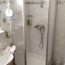 Badezimmer mit Dusche, Waschbecken und Spiegel.