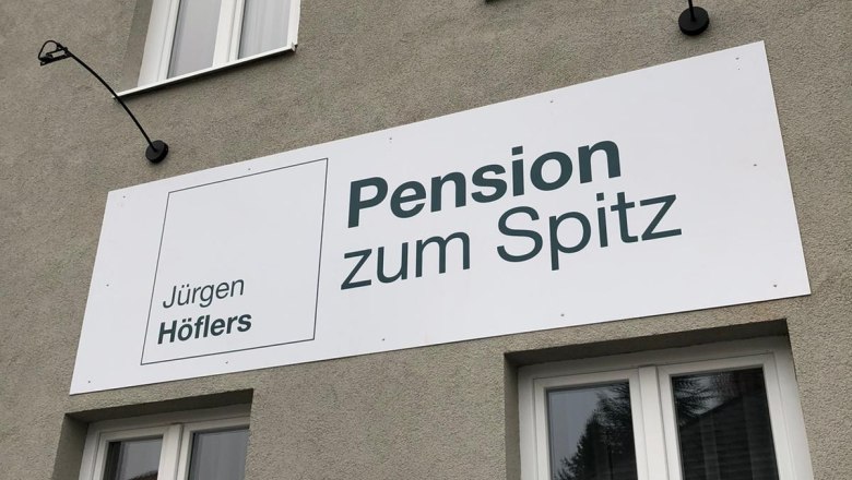 Facade of a building with a sign for the Pension zum Spitz.