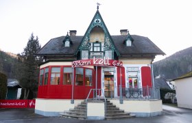 Bäckerei Koll Café in einem historischen Gebäude mit roter Fassade und dekorativem Giebel.