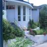 Eingang eines modernen Gebäudes mit Garten und Treppe.