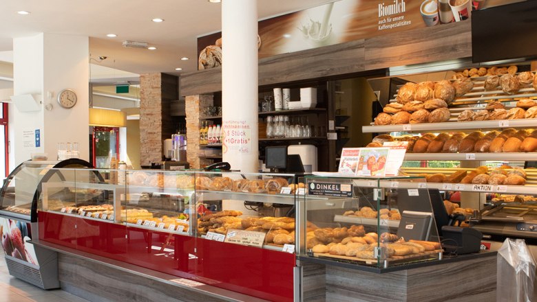 Innenansicht einer Bäckerei mit Brot und Gebäck in der Auslage.