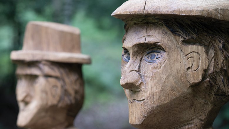 Zwei Holzskulpturen von Sagenfiguren mit Hüten in Lanzenkirchen.