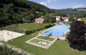 Edlitz outdoor pool with swimming pool, slide and volleyball court in a rural setting.