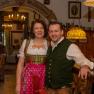 Ein Paar in traditioneller bayerischer Tracht in einem rustikalen Gasthaus.