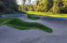 Pumptrack in Bad Sch&ouml;nau mit gr&uuml;ner Umgebung und B&auml;umen im Hintergrund.