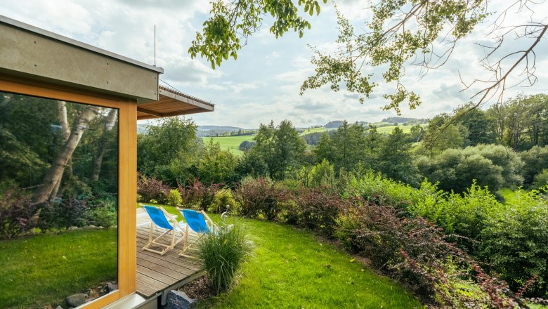 Garden with sun loungers and views of a green landscape.