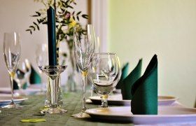 Elegant table with wine glasses, candle and folded napkins.