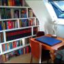 Ein gemütlicher Arbeitsbereich mit Bücherregal, Schreibtisch und Statue.
