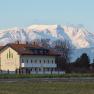 Building with the inscription 'mattone apartments' in front of a snow-covered mountain in the background.