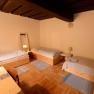 Dreibettzimmer mit Holzmöbeln und Parkettboden.
