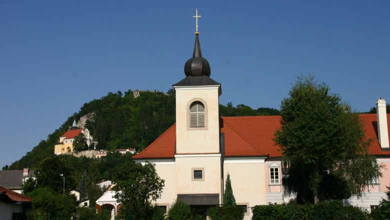 Pfarrhof Pitten mit Kirche und H&uuml;gel im Hintergrund.