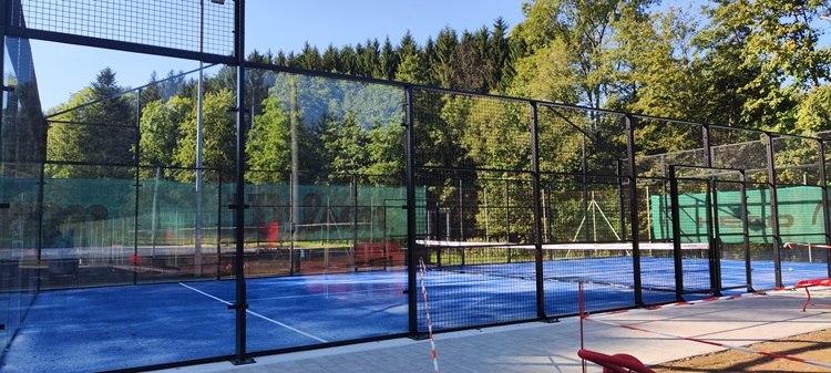 Paddle tennis court in Bad Sch&ouml;nau with blue ground and surrounding forest.