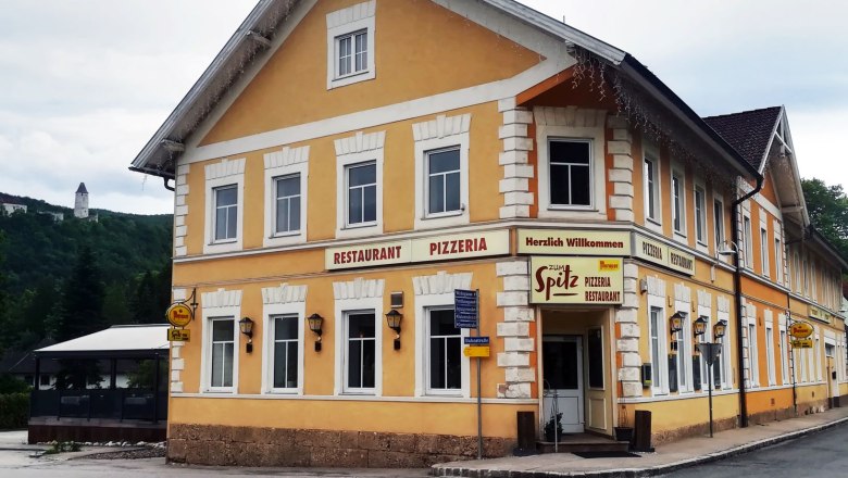 Yellow building with the inscription 'Restaurant Pizzeria Zum Spitz'.